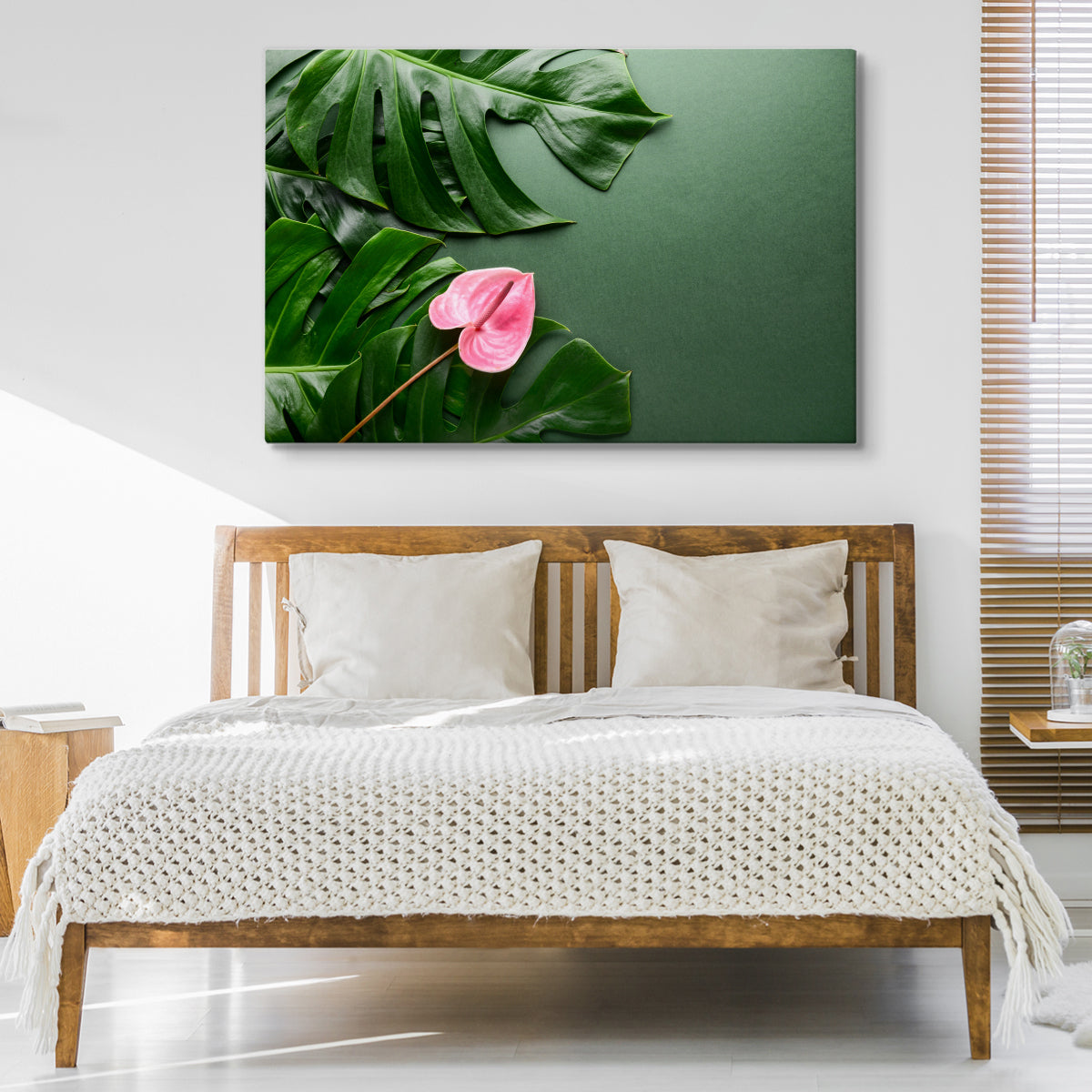 Rosa blomst på bakgrunn av monstera-blader